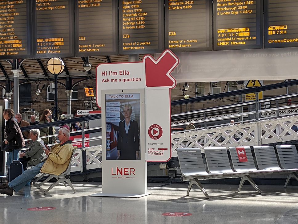 Digitaler Informations-Avatar „Ella“ am britischen Bahnsteig beantwortet Fragen von Reisenden.