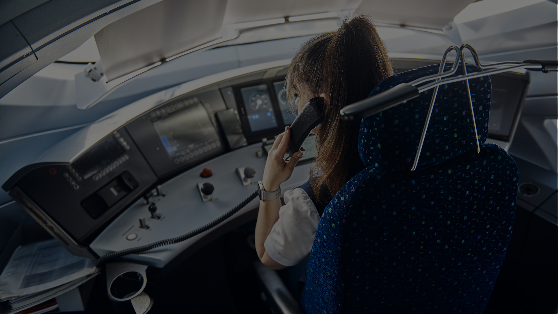 Lokführerin im Führerstand telefoniert als Beispiel für sprachgestützte Kommunikation und Übersetzung im Bahnverkehr.