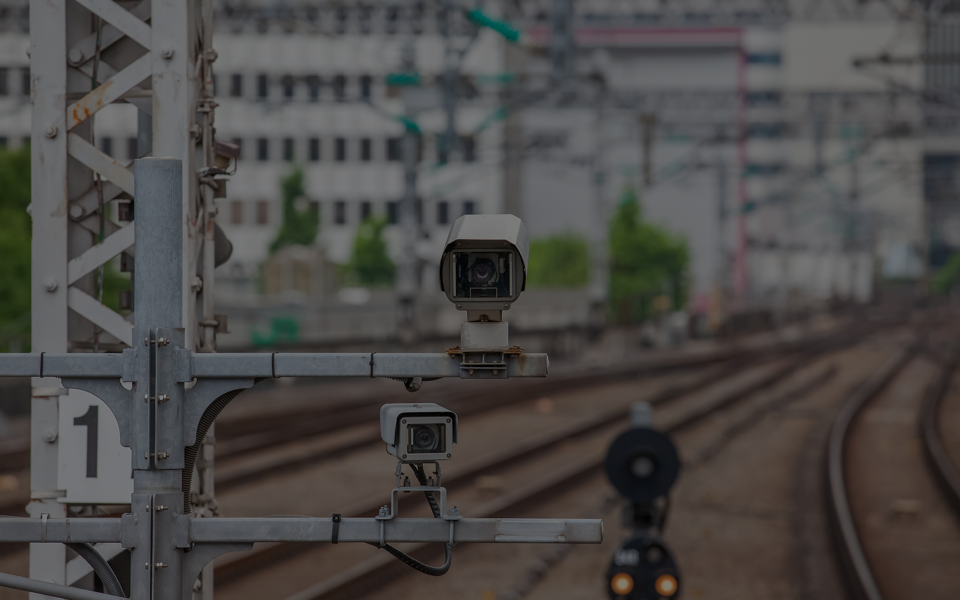 Mehrere Überwachungskameras entlang einer Bahnstrecke symbolisieren sensorbasierte Analyse im Bahnbetrieb.