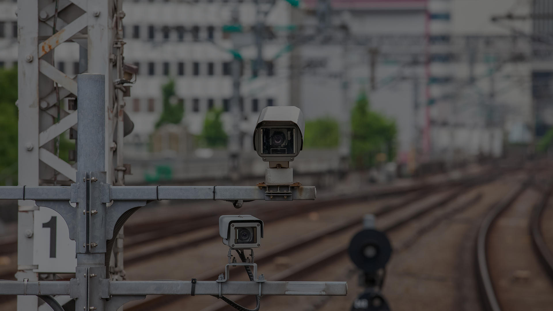 Mehrere Überwachungskameras entlang einer Bahnstrecke symbolisieren sensorbasierte Analyse im Bahnbetrieb.